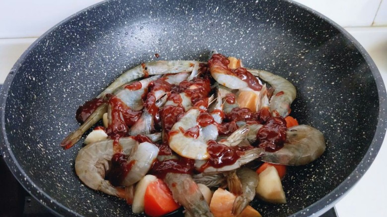 #焖锅系列#滋味大虾,最后将辣酱均匀撒在食材上面。