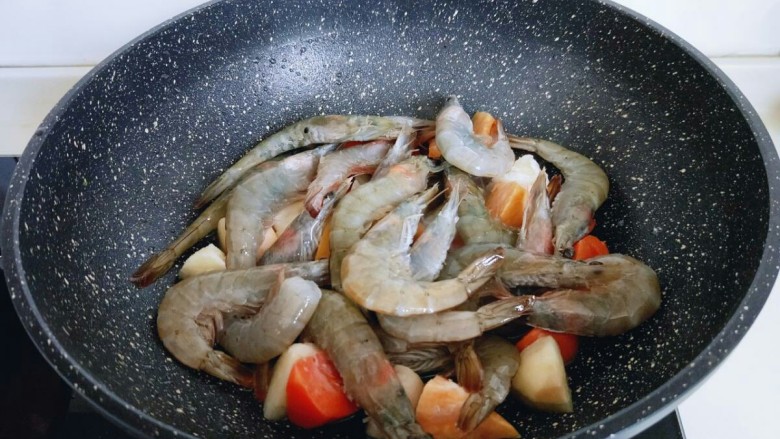 #焖锅系列#滋味大虾,再将收拾好的白虾平铺在蔬菜上面。