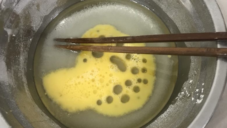  椰蓉芝麻酥球（玉米油板）,用筷子搅拌加入全蛋液。