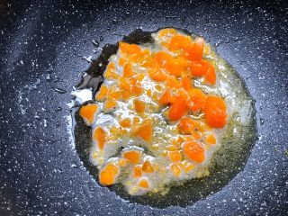 蛋黄焗南瓜,锅里剩底油，放入咸蛋黄碾碎