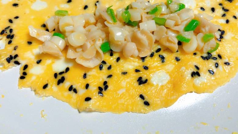 【宝宝辅食】三文鱼松厚蛋烧,待蛋液凝固，在蛋饼的一段放上海鲜菇