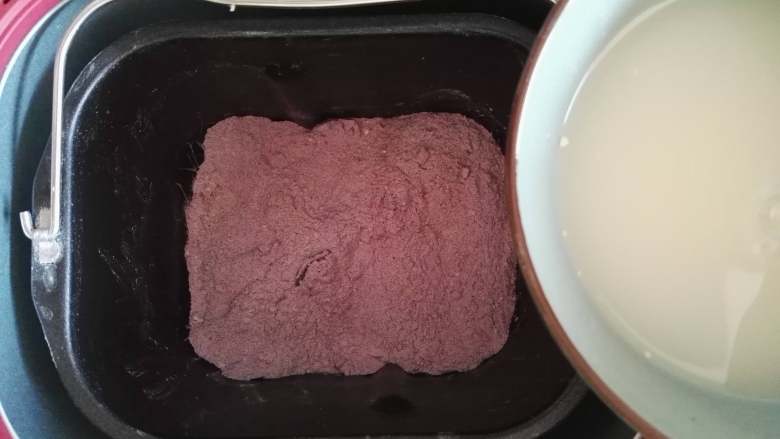 紫薯彩色馒头,将两种面粉搅拌均匀，酵母粉1克与清水120克混合后倒入面包桶里，启动揉面程序，将面团和成稍硬一点的紫薯面团取出放入盆中。
