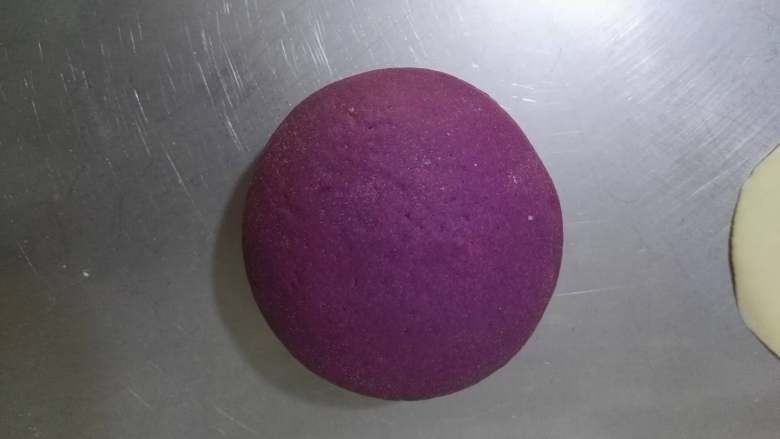 紫薯彩色馒头,收口朝下放置，将面团稍整理下成圆形。用同样的方法做好其它2个双色馒头。