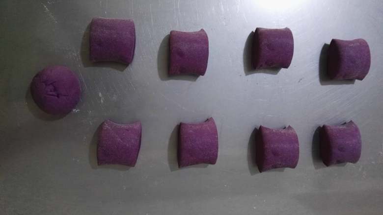 紫薯彩色馒头,饧好的紫薯面团取出，移到面板上，揉搓排气后搓成长条切成均等的9等份。