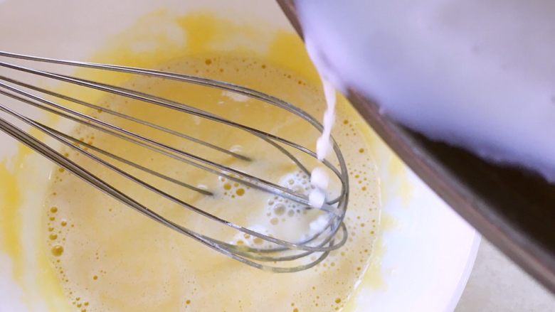 卡士达小餐包,将热牛奶一点点加入到蛋黄糊中，边加入边搅拌，直到将牛奶全部加进来