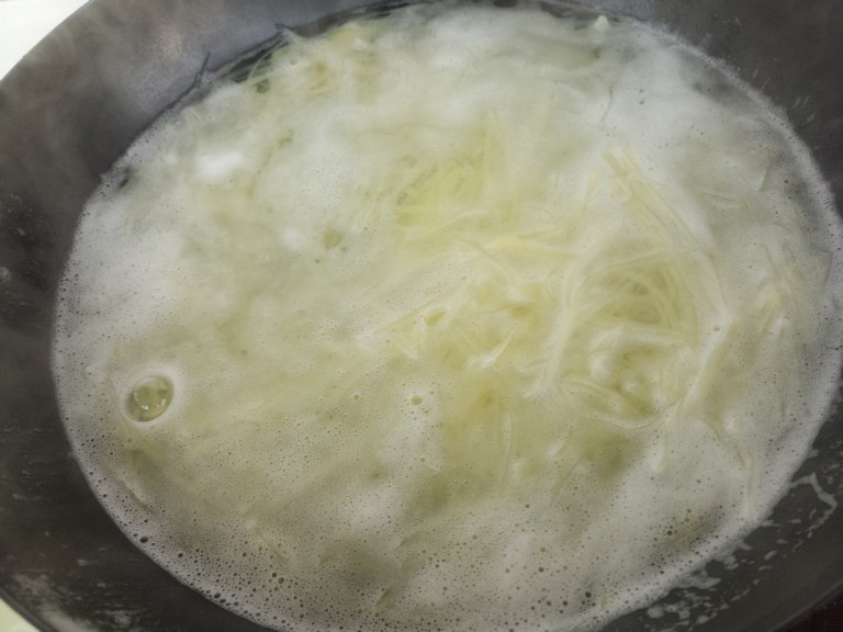 土豆丝拌洋葱丝,然后锅里烧开水，把土豆丝放进去焯水。