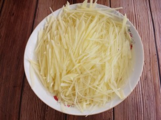 土豆丝拌洋葱丝,然后切土豆丝，用两个土豆。切好的土豆丝用水泡上。这样做是为了去除土豆中的淀粉。