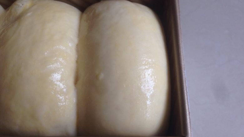  酸奶吐司,放入烤箱发酵至8、9分满（发酵温度在37度，在烤箱内放一碗热水），发酵好后的面包胚，表面刷上一层全蛋液
