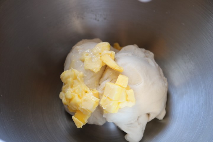 日式红豆包,用低档搅拌成团，中档揉至能拉出厚膜后加入室温软化的黄油。