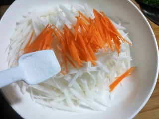 凉拌白萝卜丝,把胡萝卜和白萝卜放大的碗里，加入一勺盐。