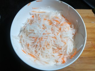 凉拌白萝卜丝,用手抓均匀，腌渍十分钟，挤去多余的水分。