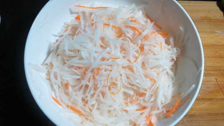 凉拌白萝卜丝,用手抓均匀，腌渍十分钟，挤去多余的水分。