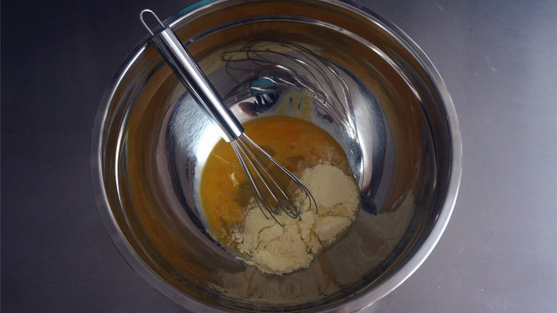 婴幼儿食谱：无油版宝宝磨牙棒,将糖粉和奶粉的混合物加入到蛋液中，搅拌均匀。
