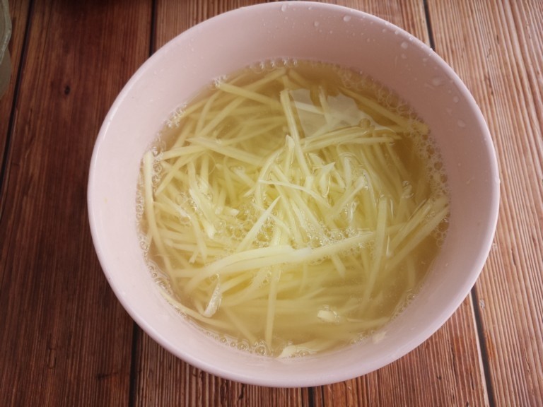 家常酸菜炒土豆丝,把切好的土豆丝放在水中泡。这样做是为了去除土豆中的淀粉。炒的时候不容易粘锅。