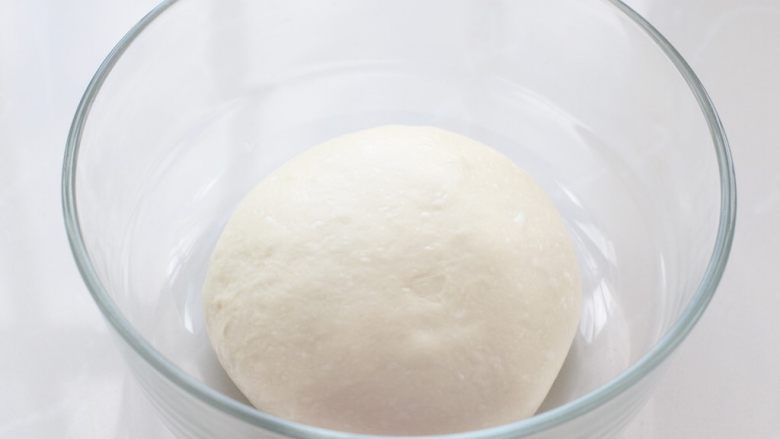 日式红豆饼,把面团整理好收口朝下放入容器中，上面覆盖保鲜膜放置温暖处进行发酵