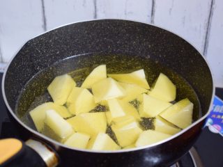 可乐土豆,锅中倒入适量的食用油烧至五六成热时放入土豆炸熟