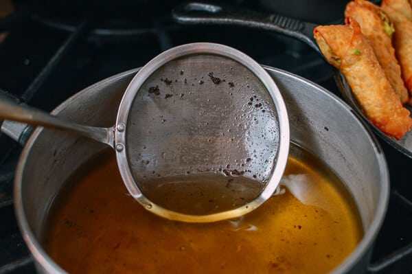 牛油果蛋卷,在煎炸过程中，要用细滤网来去除油里面的颗粒。