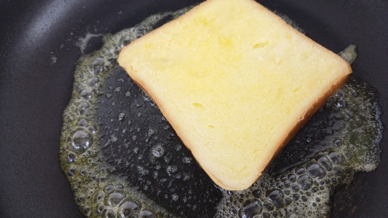 黄油煎吐司,接着把吐司放入锅里煎，小火煎。