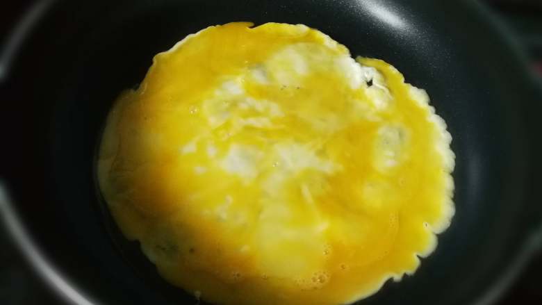 西红柿鸡蛋面,油热后，倒入蛋液，摊成鸡蛋饼