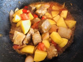 番茄土豆炖牛腩,然后放入西红柿炒软。把锅中的香葱结和姜片挑出，加入牛腩块煸炒至表面收紧，加入切好的土豆块。