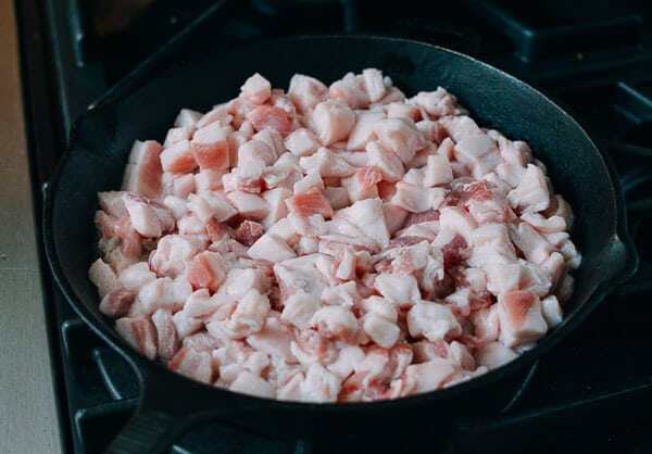 炼制猪油,把肉块跟半杯冷水加到锅里。 