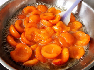杏酱,随着不断加热，糖会慢慢融化。渐渐地会渗出更多的水，因为选择的是熟透发软的杏，所以这个时候杏已经开始变得软烂。一直加热至杏煮开。