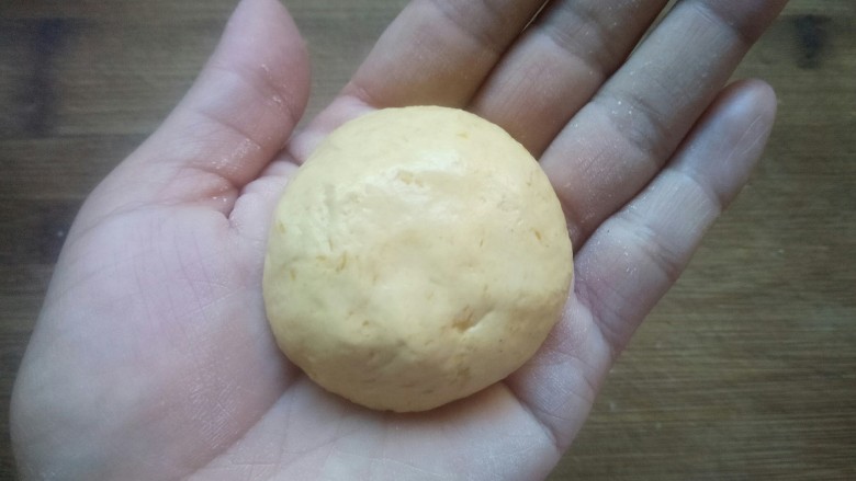 芝香南瓜饼,取约30克的面团揉圆（如果嫌太粘，可以在手上涂抹点油）。
