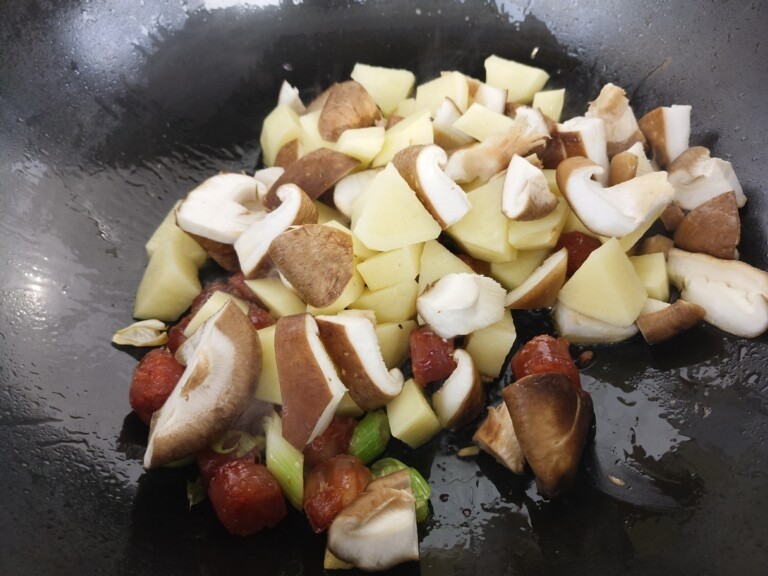 香菇腊肠焖饭,再放入切好的香菇和土豆一起炒。