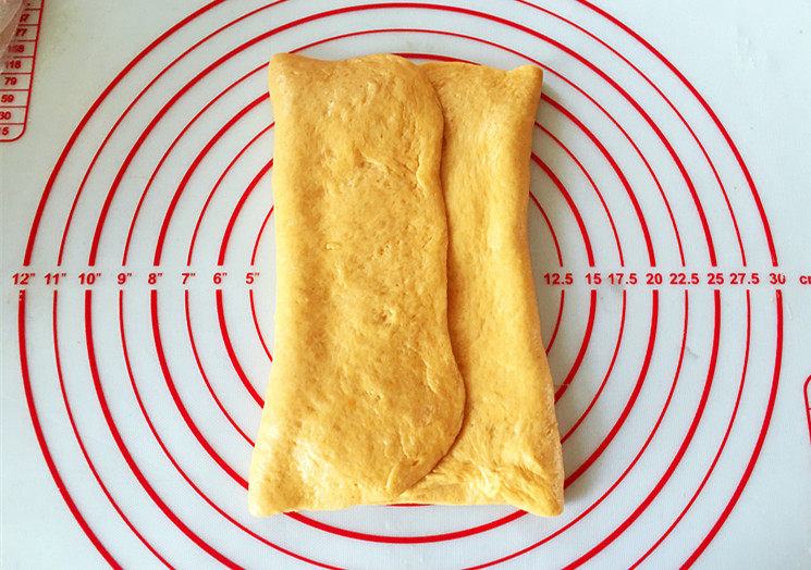 全麦南瓜面包,将左右两边分别向中间折叠，两边重叠到一起之后，捏紧所有的缝隙。