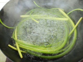 手撕蒜苔,先把水烧开，把蒜苔放进锅里煮。