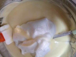 自制酸奶蛋糕,把打发的蛋清分三次加入面糊中用刮刀“之”字搅拌均匀即可