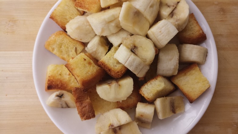 黄油吐司香蕉沙拉,把它和香蕉放在一个盘子里。