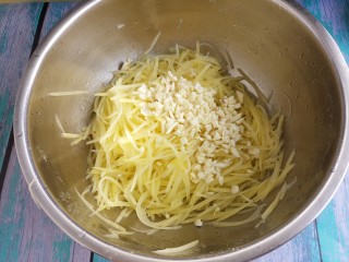 夏日凉拌土豆丝,然后切蒜末，把土豆丝和蒜末放在一个大盆里