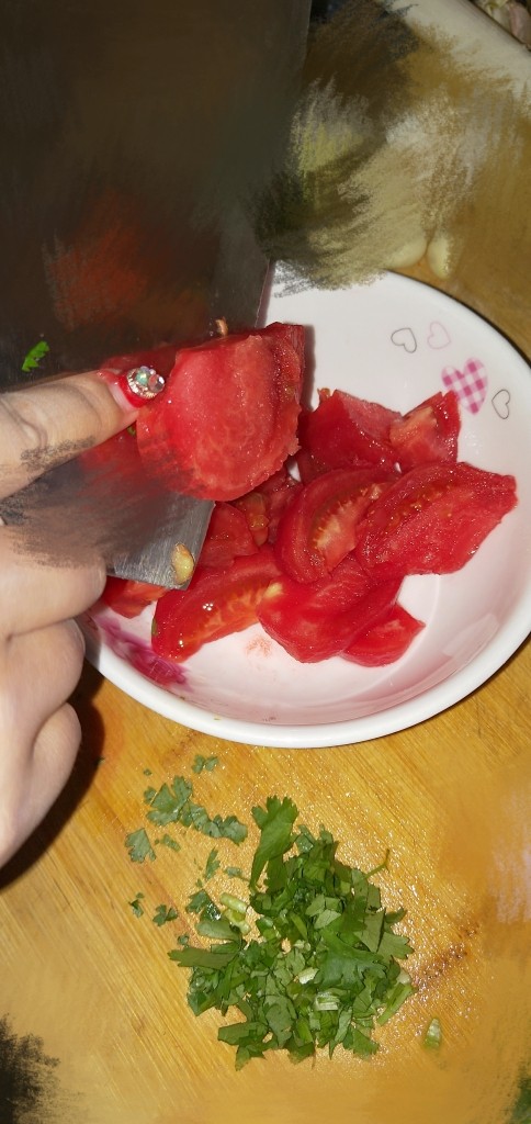 酸汤龙利鱼,将去了皮的西红柿放在手中切片，保证西红柿汤汁不会流失