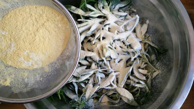 忆苦思甜的野菜扒拉,趁着面条菜叶片上还挂着水，将小麦粉和玉米粉混合均匀后用筛子筛在面条菜上。