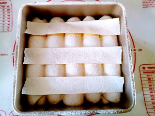 全麦奶香南瓜排包,将三条等宽的油纸等距放在发酵好的面包上，用细一些的筛子，筛粉。