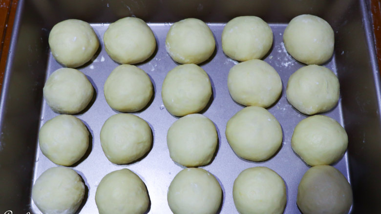 南瓜小餐包,揉匀，平均分割成20个面团，排列整齐，盖上保鲜膜。(差不多每个45克)