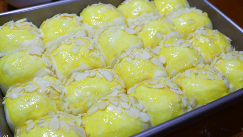 南瓜小餐包,表面刷一层蛋黄液或是牛奶，随意撒上杏仁片或是白芝麻都不错。