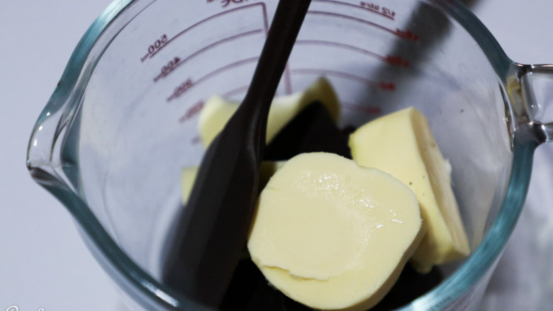醇黑巧克力裂纹曲奇,以上食材适用于学厨金色12连不粘无比牌曲奇模具一份用量。
黄油，黑巧克力隔开水融化，加入糖粉搅匀。