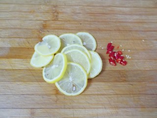 泡椒柠檬花生鸡爪,柠檬用盐搓洗干净切成片，小米椒洗干净切碎。