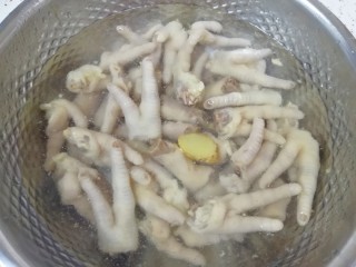 泡椒柠檬花生鸡爪,准备一盆冰水，将煮好的鸡爪放进去浸泡几分钟。