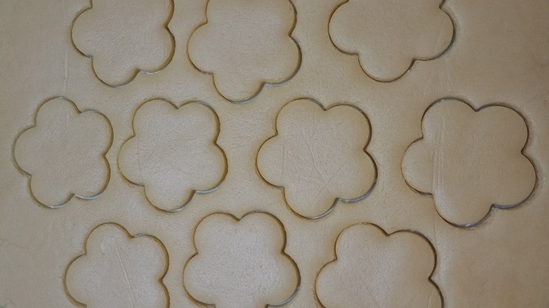 菠萝酱饼干,用花朵模具印出形状，如果做8个饼干，就要印出16朵花形，另外八个用圆形模具印出花心。