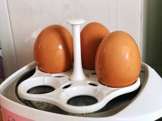 快手营养早餐11,先把鸡蛋放进蒸蛋器里，加水加盖，按下电源，就可以暂时不用管它了，去处理其他食材；