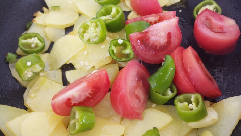西红柿炒土豆片,加入西红柿和青椒。
