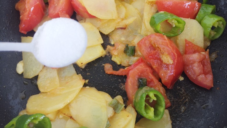 西红柿炒土豆片,然后继续翻炒，加一勺盐。