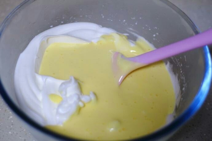 芒果蛋糕卷,将拌好的蛋黄糊倒入到蛋白盆中

