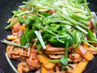 干锅鸡翅,放入青辣椒片和芹菜段翻炒1分钟