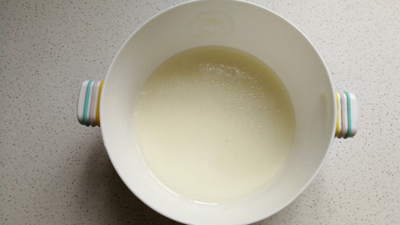 足球慕斯蛋糕卷,玉米油和牛奶放入容器中，用手动打电器搅拌至乳化状态。