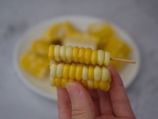 孜然玉米串,用牙签插入玉米粒，然后用手掰开，如图