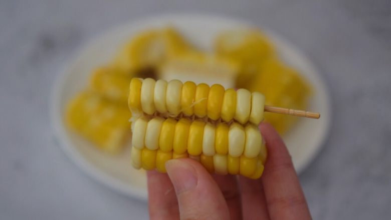 孜然玉米串,用牙签插入玉米粒，然后用手掰开，如图
